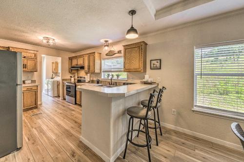 a kitchen with a large counter and stools in it at Peaceful Alto Home with Deck about 12 Mi to Ski Apache! in Alto