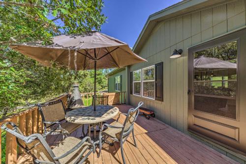 a patio with a table and chairs and an umbrella at Peaceful Alto Home with Deck about 12 Mi to Ski Apache! in Alto
