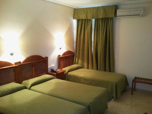 A bed or beds in a room at Hotel Castillo de Montemayor