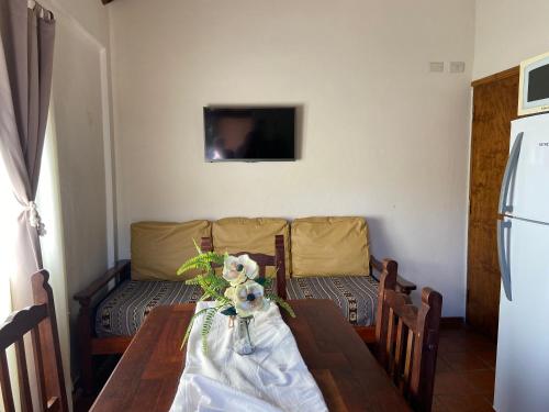 a dining room table with a vase of flowers on it at TOLHUIN COLON in Colón