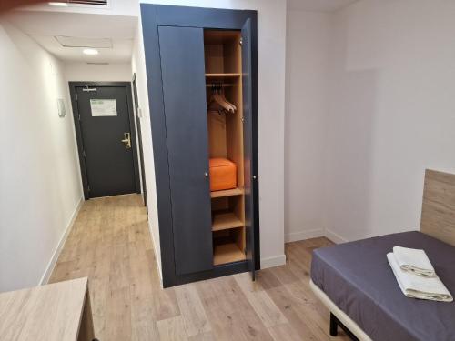 a room with a closet with a bed and a door at Micampus Leganés Student Residence in Leganés