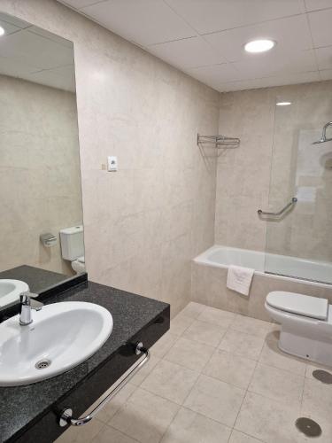 a bathroom with a sink and a toilet and a tub at Micampus Leganés Student Residence in Leganés