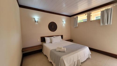 1 dormitorio con 1 cama con edredón blanco en Pousada Aquário, en Isla de Boipeba