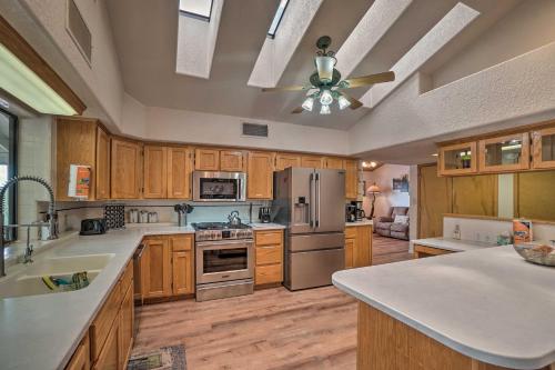 a large kitchen with wooden cabinets and a ceiling fan at Cozy Pine Retreat with Private Hot Tub and Views in Pine