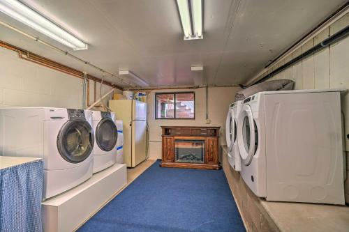 a laundry room with three washing machines and a fireplace at Cozy Pine Retreat with Private Hot Tub and Views in Pine
