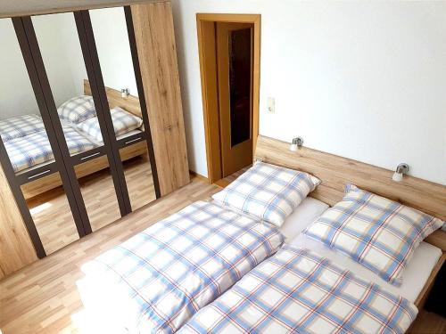um quarto com três almofadas numa cama com um espelho em Ferienwohnung Erzgebirge em Lauter