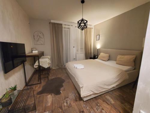 een slaapkamer met een bed, een bureau en een televisie bij Sleep and drive cosy in Sarajevo