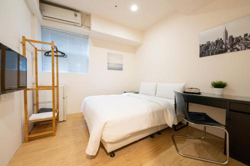 a bedroom with a bed and a desk and a desk at HotelsHere - Ximen in Taipei