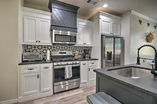 a kitchen with white cabinets and stainless steel appliances at Bright Amarillo Townhome Near Parks and Town! in Amarillo