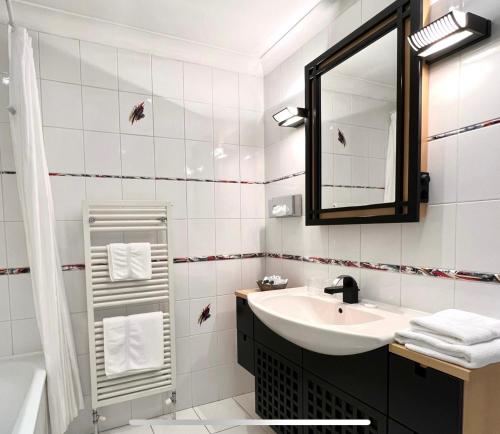 a white bathroom with a sink and a mirror at Promenade House in Douglas