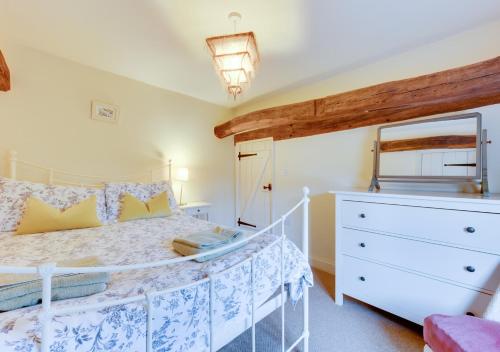 a bedroom with a white bed and a dresser at 1 Church Farm in Blythburgh
