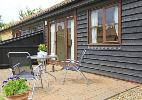 a table and chairs on a patio in front of a house at The Tack Room in Wangford