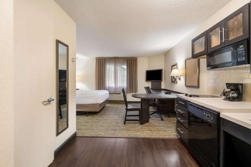 a hotel room with a king bed and a desk at Sonesta Simply Suites Hampton in Hampton