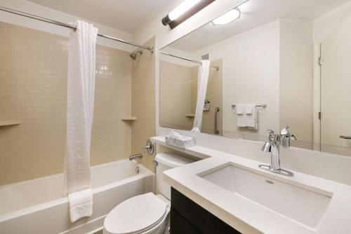 a bathroom with a sink and a toilet and a tub at Sonesta Simply Suites Hampton in Hampton