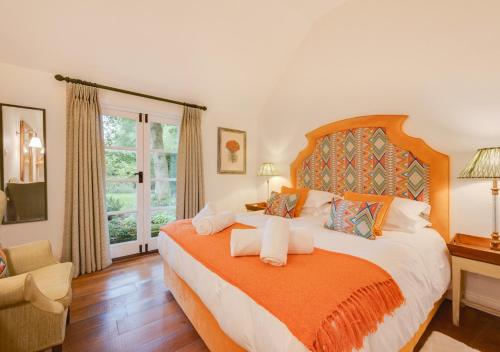 a bedroom with a large bed with an orange blanket at The Potting Shed 