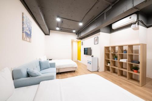 sala de estar con sofá y cama en una habitación en HotelsHere - Ximen en Taipéi