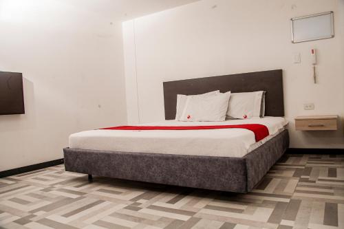 um quarto com uma cama grande e paredes brancas em Hotel Star Pasto em Pasto