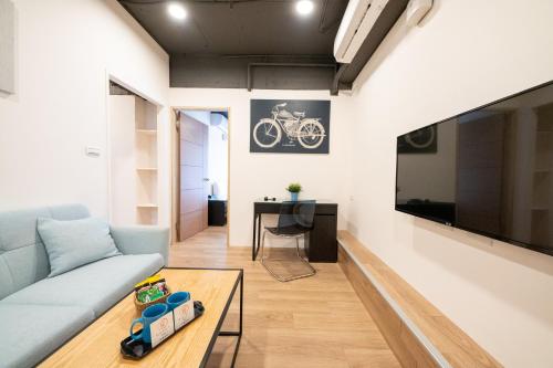 a living room with a couch and a tv at HotelsHere - Ximen in Taipei