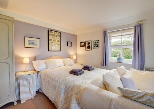 a bedroom with a bed and a couch and a window at Garden Cottage The Old Mill in Snape