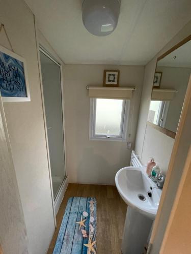 a bathroom with a sink and a mirror at Impeccable 4-Bed Caravan in Clacton-on-Sea in Clacton-on-Sea
