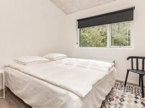 een witte slaapkamer met een groot bed en een raam bij 6 person holiday home in Hjørring-By Traum in Lønstrup