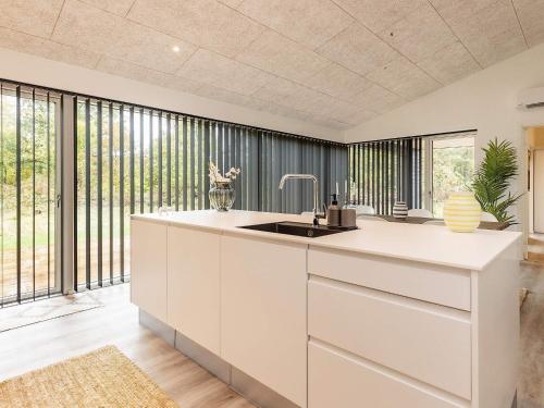 cocina con fregadero y ventanas grandes en Three-Bedroom Holiday home in Hjørring 6, en Lønstrup