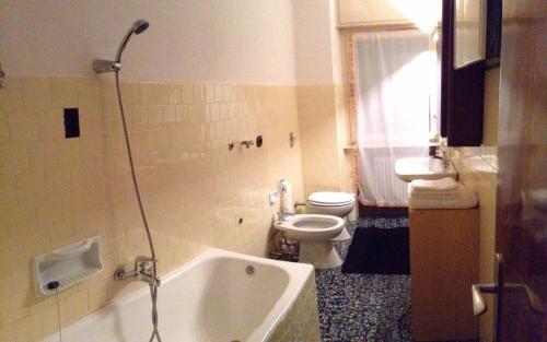 a bathroom with a tub and a toilet and a sink at Casa ai Dossi in Bellamonte