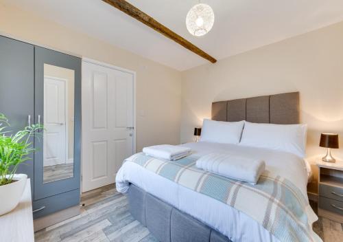 um quarto com uma cama grande e almofadas brancas em Ardley Cottage Hedgehog em Waldingfield