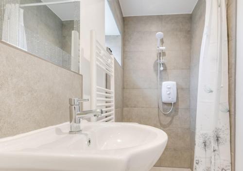 uma casa de banho com um lavatório e um chuveiro em Ardley Cottage Hedgehog em Waldingfield