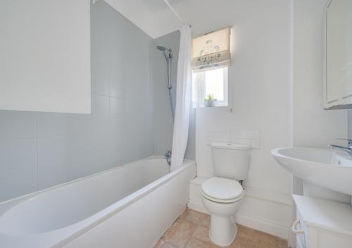 a white bathroom with a toilet and a sink at The Haven in Snape