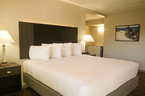 a hotel room with a large bed with white pillows at Americana Modern Hotel in Redding
