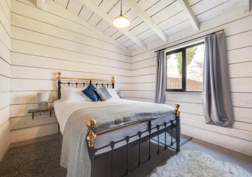 um quarto com uma cama e uma janela em The Cowshed em Crowfield