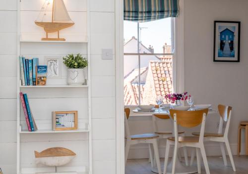 a dining room with a table and a window at The Hideaway in Southwold