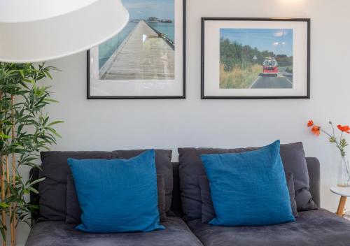 ein Sofa mit blauen Kissen im Wohnzimmer in der Unterkunft The Hideaway in Southwold