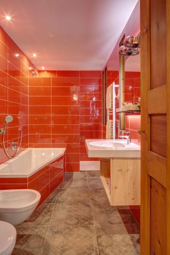 a bathroom with a tub and a sink and a toilet at Frida am Wald in Rasùn di Sotto