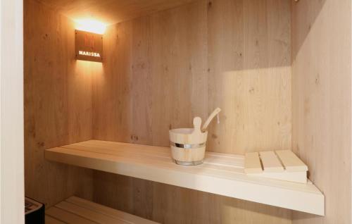 Baño pequeño con pared de madera y estante en Gorgeous Home In Lembruch-dmmer See With Sauna, en Lembruch