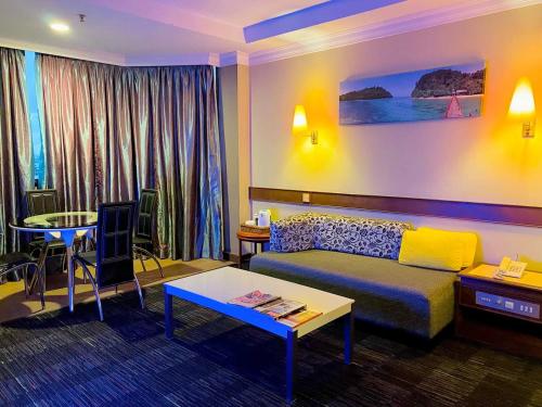 فندق غراند كريستال في ألور سيتار: غرفة معيشة مع أريكة وطاولة