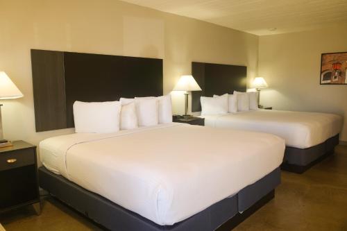 a hotel room with two beds with white pillows at Americana Modern Hotel in Redding