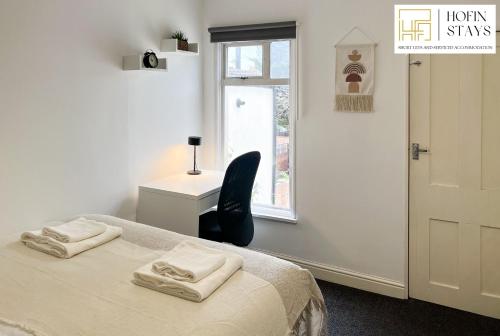 a bedroom with a bed and a chair and a window at 2 Modern Double Bed Apartment for 5 Guests By Hofin Stays Short Lets & Serviced Accommodation in Dartford
