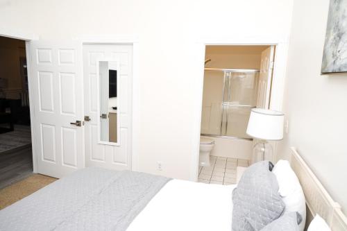 a white bedroom with a bed and a bathroom at Stunning Condo on Golf Course Near Broadway at the Beach in Myrtle Beach