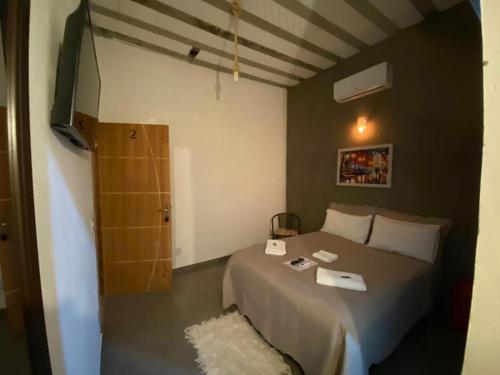 a bedroom with a bed and a door to a bathroom at Pousada Recanto Querubins in Paty do Alferes