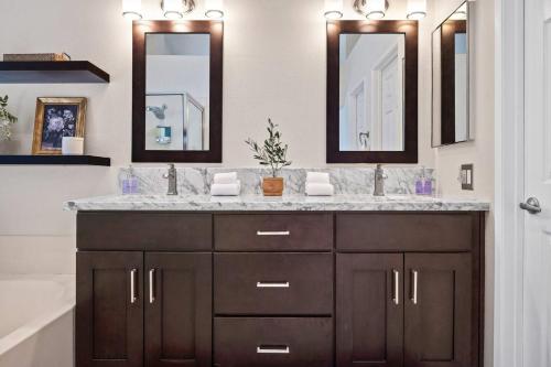 a bathroom with a sink and two mirrors at Golden Desert Getaway Family Friendly Home in Indio