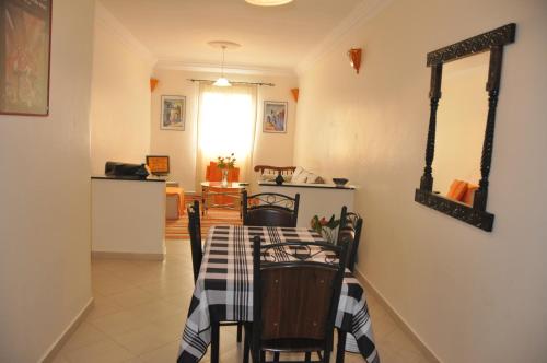 a dining room with a table and a kitchen at Résidence La Galiote in Essaouira