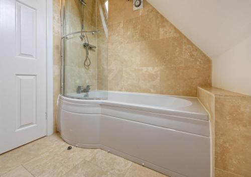 a bathroom with a white tub and a shower at 248 Cae Du in Abersoch