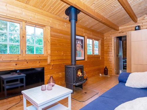 a living room with a stove in a log cabin at Holiday home Toftlund XLIV in Toftlund