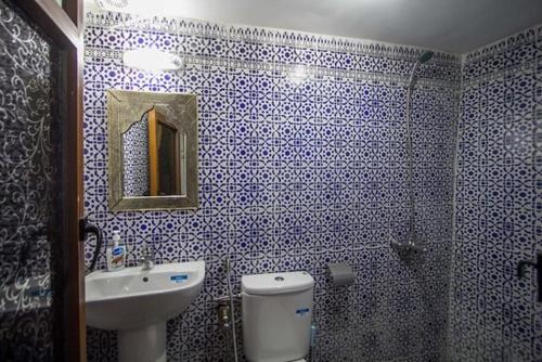 baño azul y blanco con aseo y lavamanos en Dar Miouda Fes en Fez