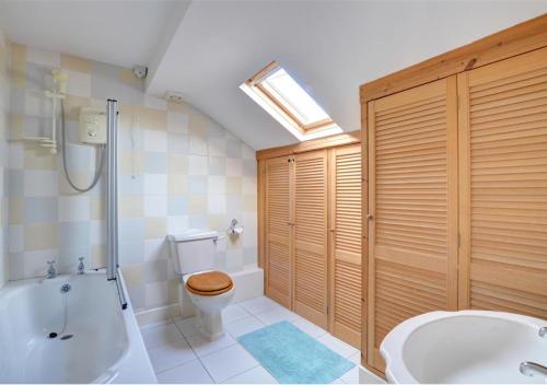 a bathroom with a tub and a toilet and a sink at 3 Tyn Llan in Dyffryn