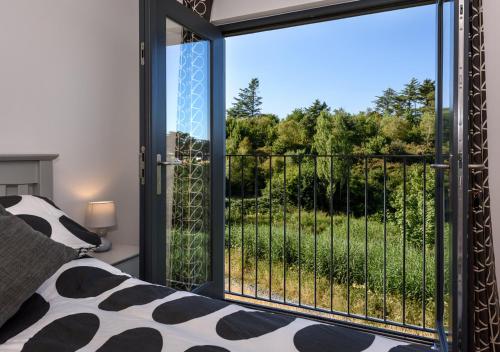a bedroom with a window with a view of a garden at 9 Pen y Bont in Abersoch