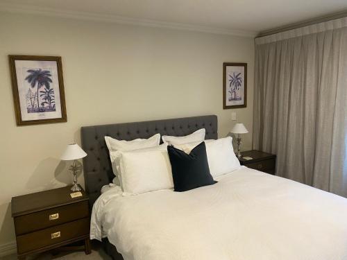 um quarto com uma cama grande e almofadas pretas e brancas em West End Precinct 2 Bedroom Apartment close to walkway and ocean em New Plymouth