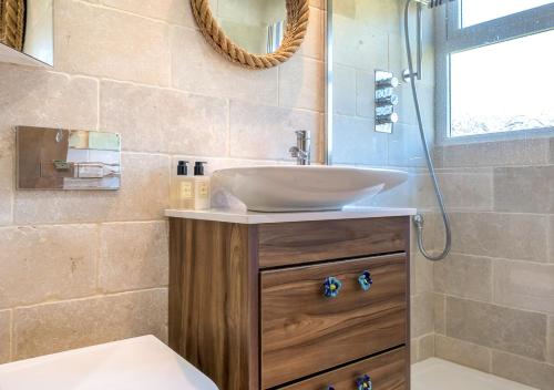 La salle de bains est pourvue d'un lavabo et d'une douche. dans l'établissement 9 Braich Farm, à Llanengan